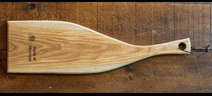 Handmade wooden serving board with a long shaped handle, showcasing natural hardwood grain, crafted by Made at Montrose in Lancashire.