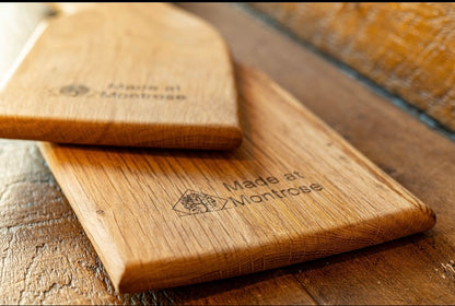 Close-up of handcrafted wooden serving boards showing natural hardwood grain and engraved Made at Montrose branding, handmade in Lancashire.