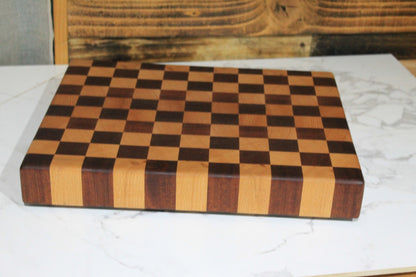 Front view of handmade end grain chequered chopping board showing its alternating hardwood blocks and thick solid wood construction. 