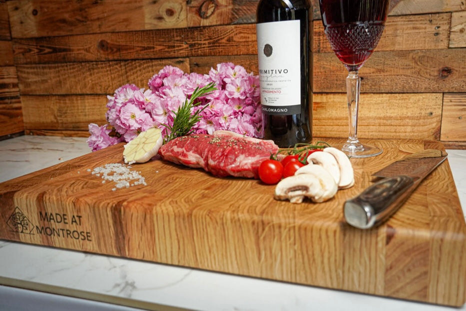 Angled view of the Montrose Edition solid oak end grain chopping board, displaying its thick wooden construction and food presentation